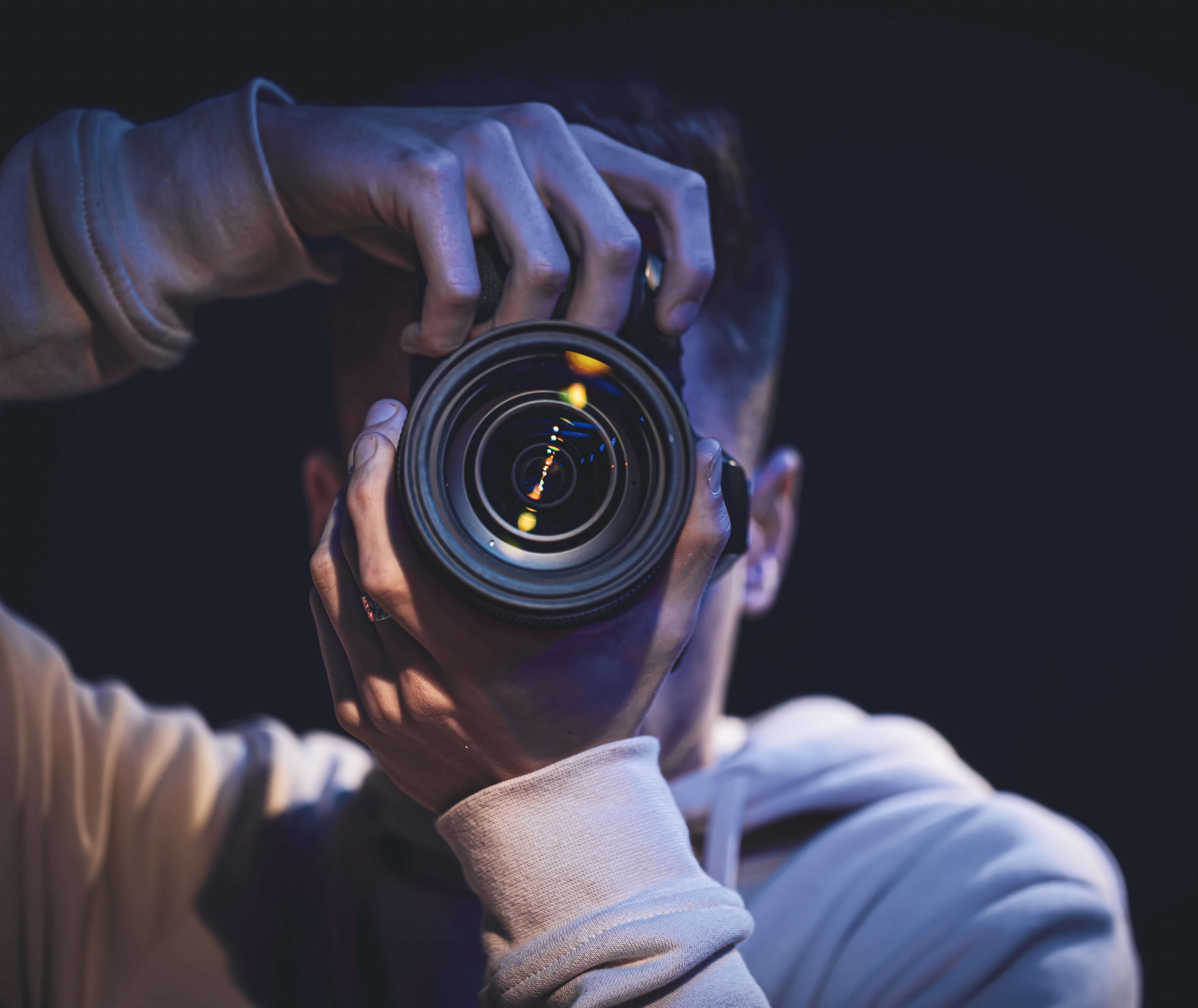 manphotographerwithcameratakesphotodarkcopyspace_q3mdm_4335